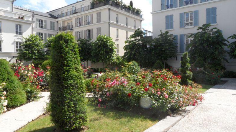 a building with a bunch of flowers in front of it at HolidayApartment Val d'Europe in Chessy