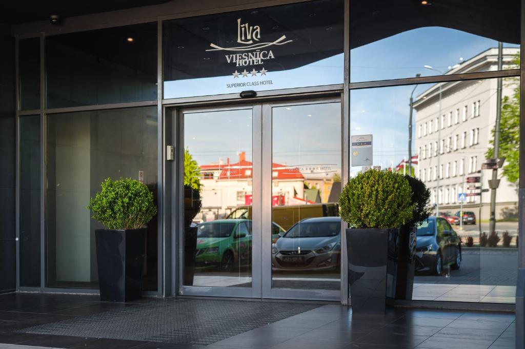 a store front with a large window and a large building behind it at Liva Hotel in Liepāja