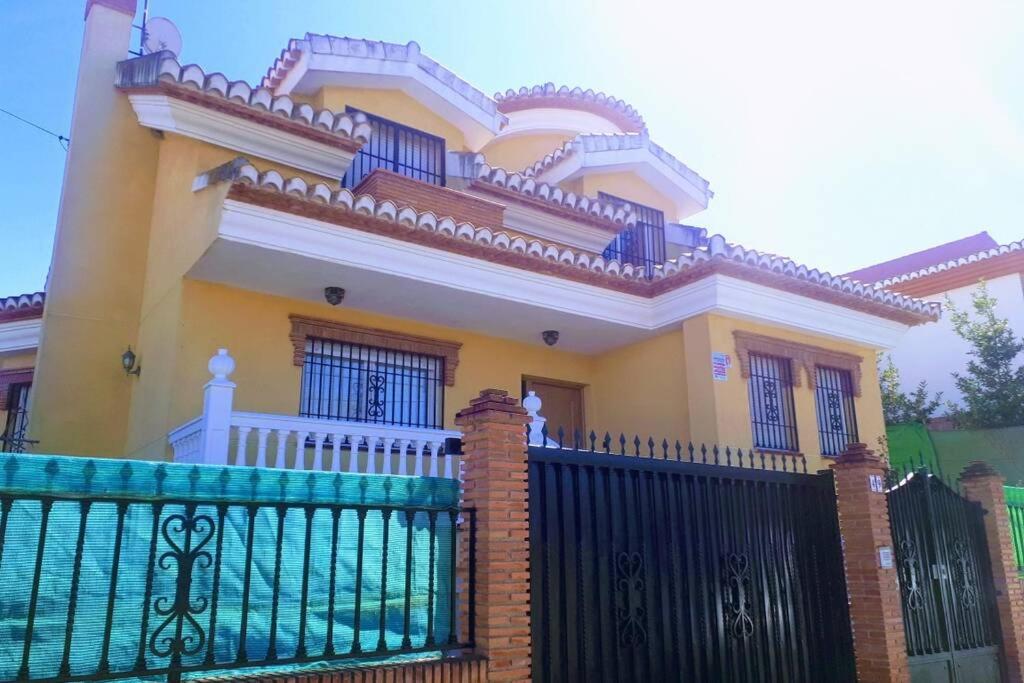duży żółty dom z czarnym płotem w obiekcie Casa rural a 20 minutos de la Alhambra w Grenadzie