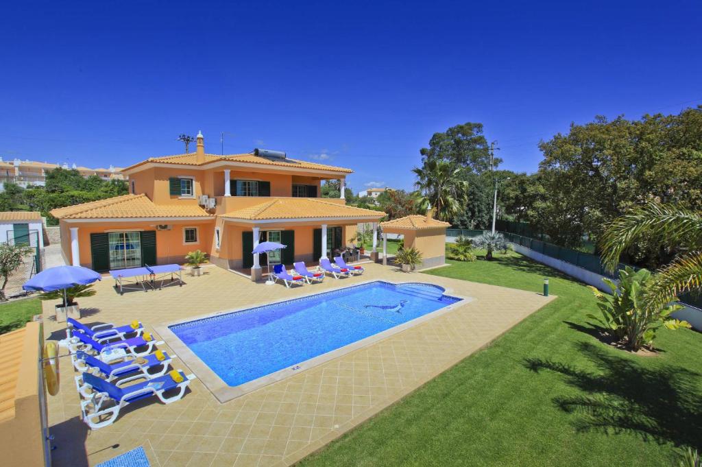 a villa with a swimming pool in front of a house at Villa João Paulo in Albufeira