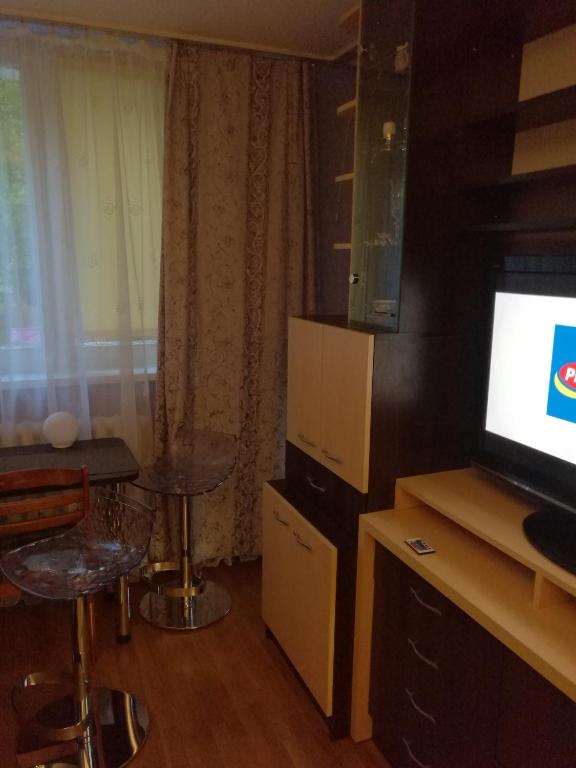 salon z telewizorem, stołem i krzesłem w obiekcie Flat Trocka Street w Warszawie