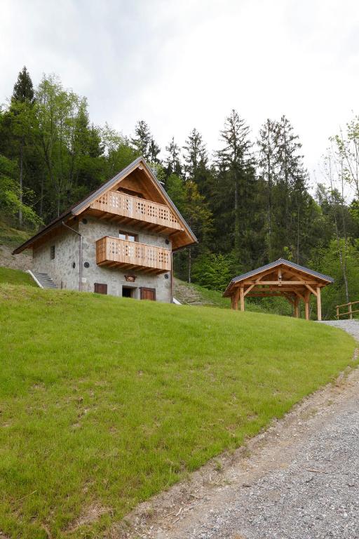 un edificio in cima a una collina erbosa di Albergo Diffuso Sutrio Zoncolan a Sùtrio