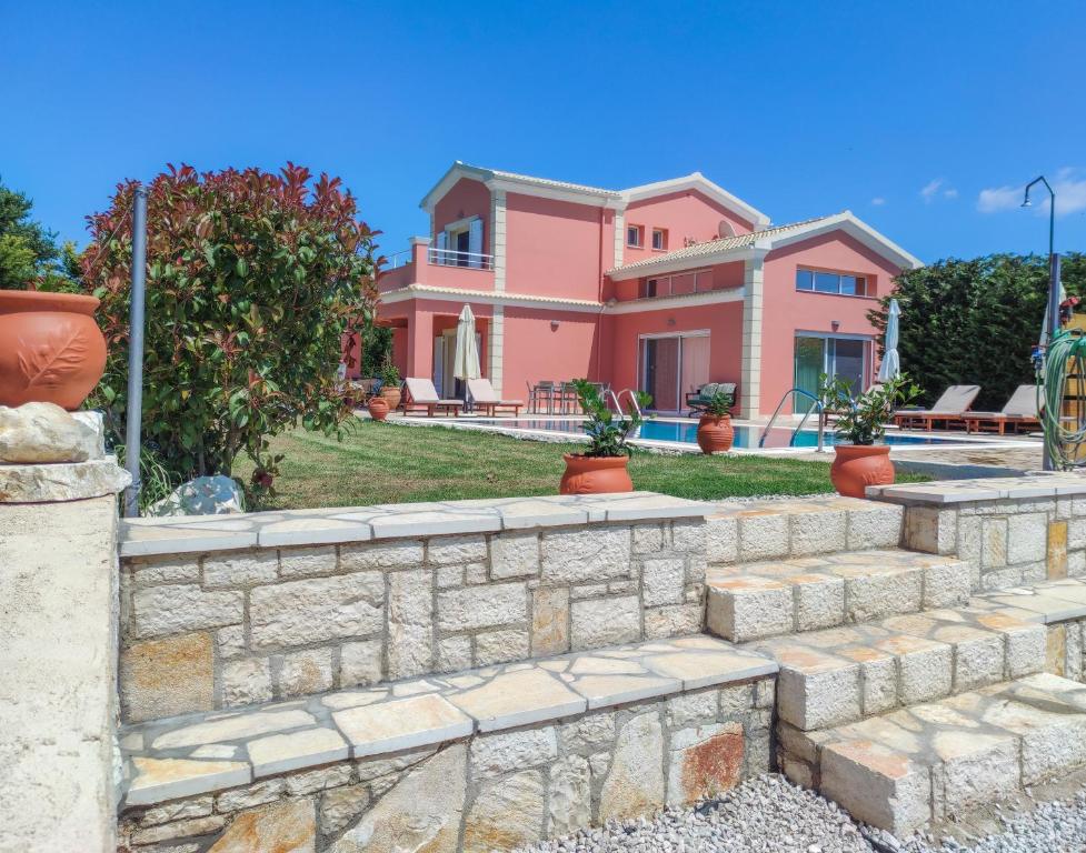ローダにあるVilla Roda Park Corfuの石壁の大ピンクの家