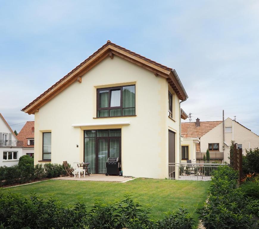 una casa blanca con un patio de césped en Ferienhaus Alte Glaserei, en Neustadt an der Weinstraße