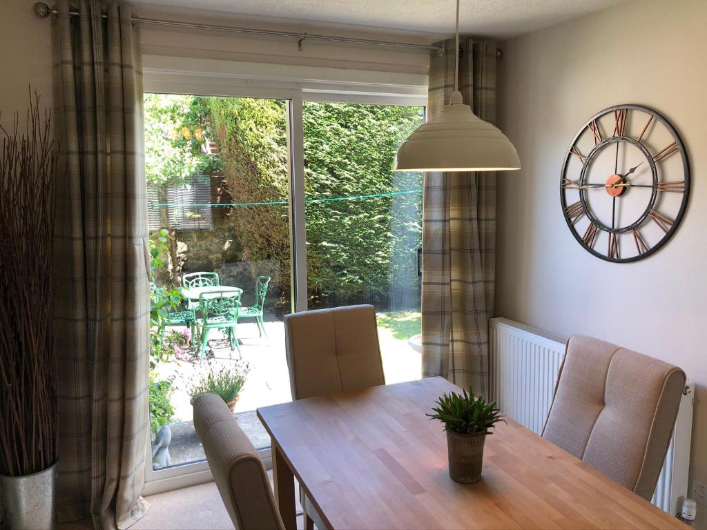 a dining room with a table and a clock on the wall at St Margaret's Cottage, Edinburgh in Edinburgh