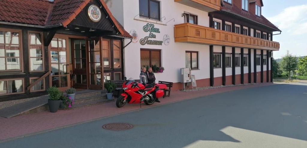 dos personas en motocicleta estacionadas frente a un edificio en Hotel Igelstadt, en Fürstenberg