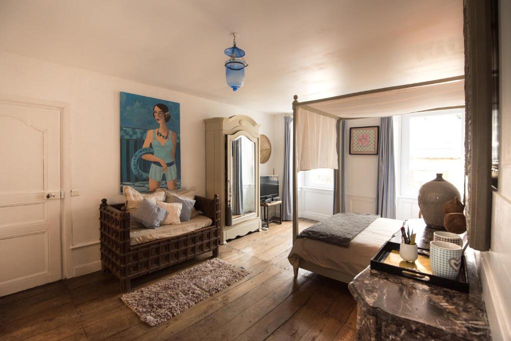 sypialnia z łóżkiem, kanapą i lustrem w obiekcie Les Chambres de Lourmel w mieście Pontivy