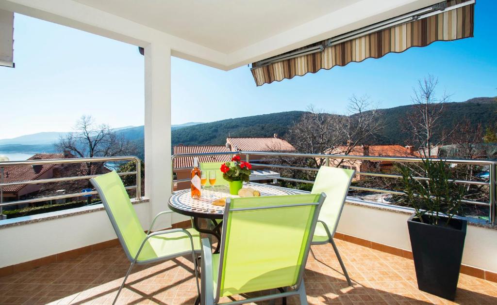 a patio with a table and chairs on a balcony at Apartmani Škopac Rabac in Rabac