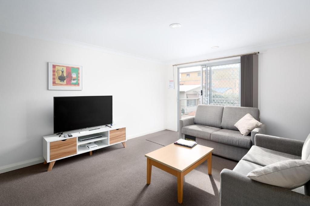 a living room with a couch and a tv at Bayview Apartments by Classic Holidays in Cowes
