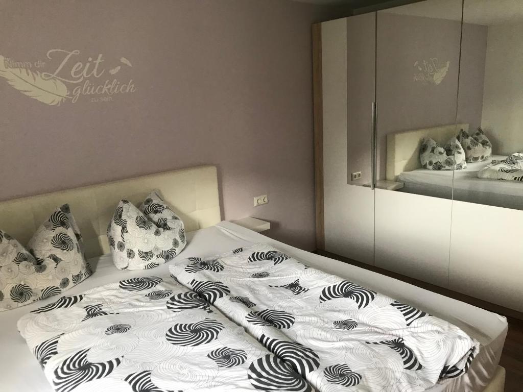 Bett mit einer weißen und schwarzen Bettdecke und Kissen in der Unterkunft Haus Elvira in Klösterle am Arlberg