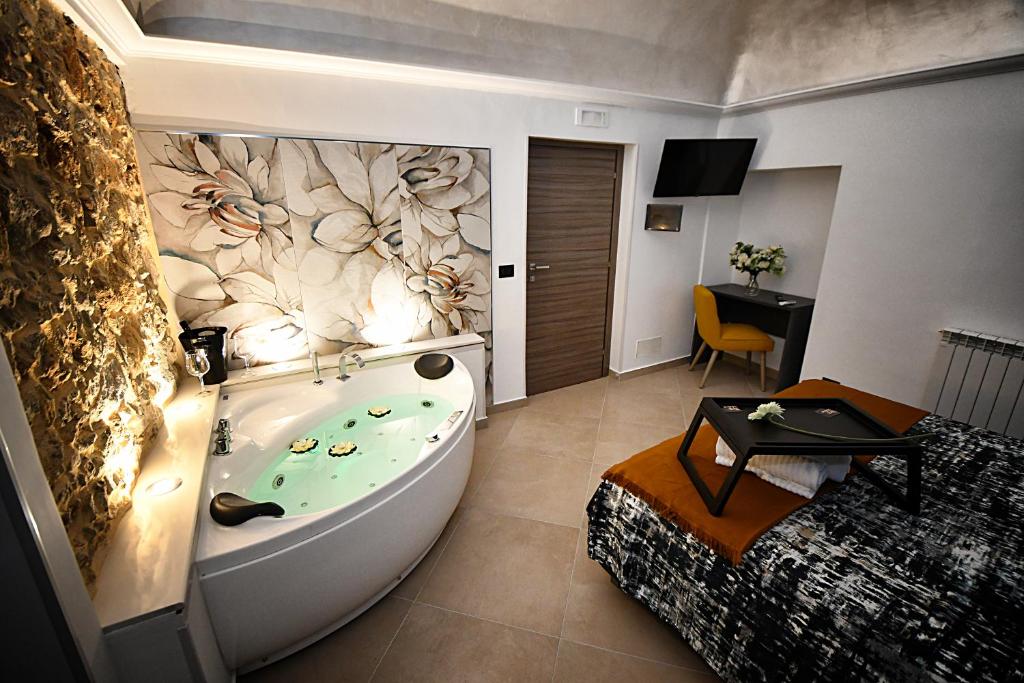 a bathroom with a tub in a room with a bed at B&B AURORA in Piazza Armerina