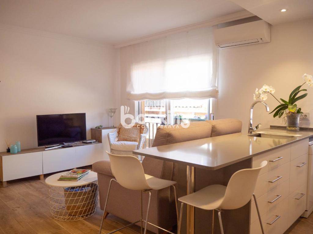 cocina con fregadero, mesa y sillas en Indústria Apartament per 3 persones a 2 minuts de la platja amb Aire acondicionat i plaça d'aparcament, en Sant Feliu de Guíxols