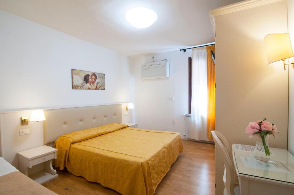 ein Hotelzimmer mit einem Bett und einem Tisch in der Unterkunft Albergo ai Tolentini in Venedig