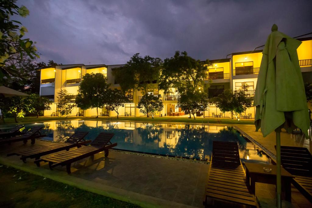 a hotel with a swimming pool at night at Grand Tamarind Lake in Kataragama