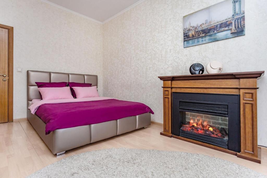 a bedroom with a bed and a fireplace at Studiominsk 6 Apartments in Minsk