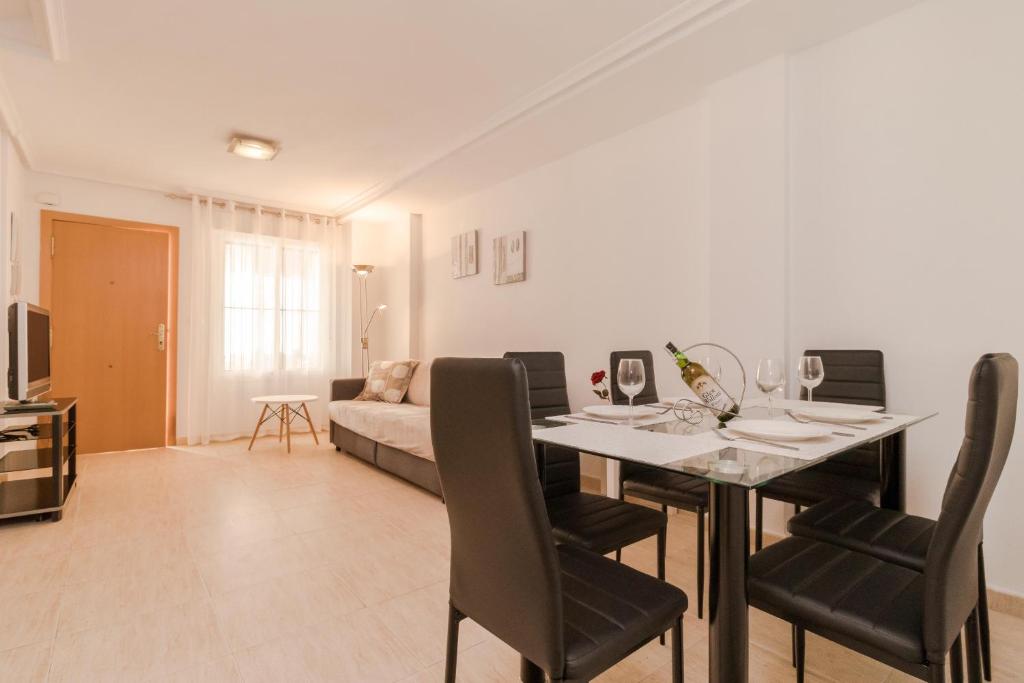 een woonkamer met een tafel en een bank bij Espanatour AGUAMARINA in Torrevieja