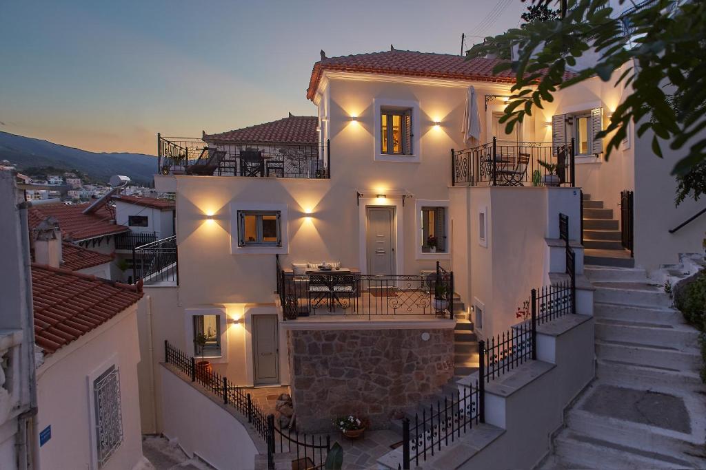 uma grande casa branca com escadas e luzes em Euphoria House em Poros