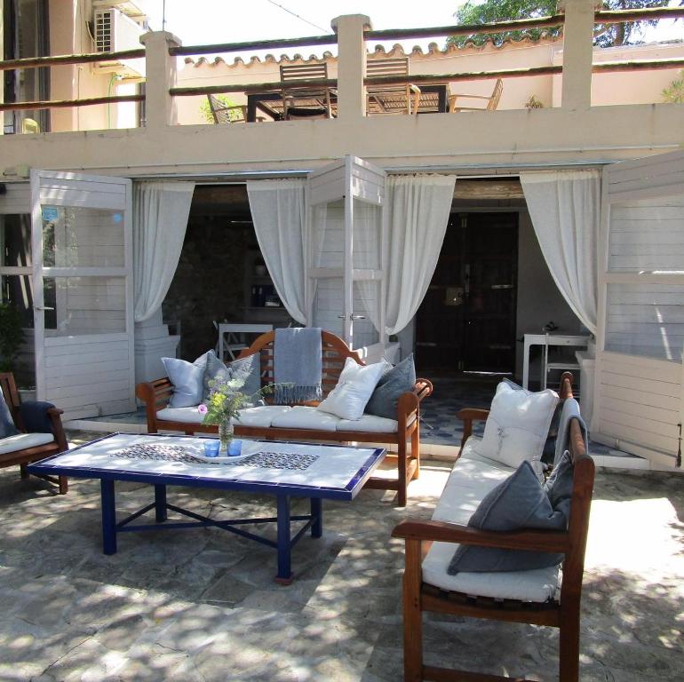 un patio con sofás, mesa y sillas en Casa Pura Vida, en Villanueva de Algaidas