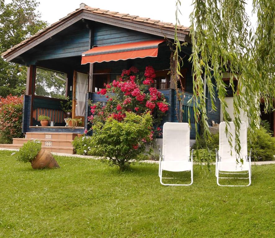 two white chairs sitting in the grass in front of a house at Casa Azul in Santillana del Mar