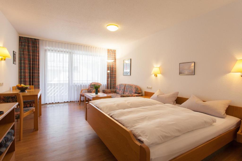 - une chambre avec un grand lit et un salon dans l'établissement Rustikales Apartment 35qm mit Balkon Nähe Freiburg, à Simonswald