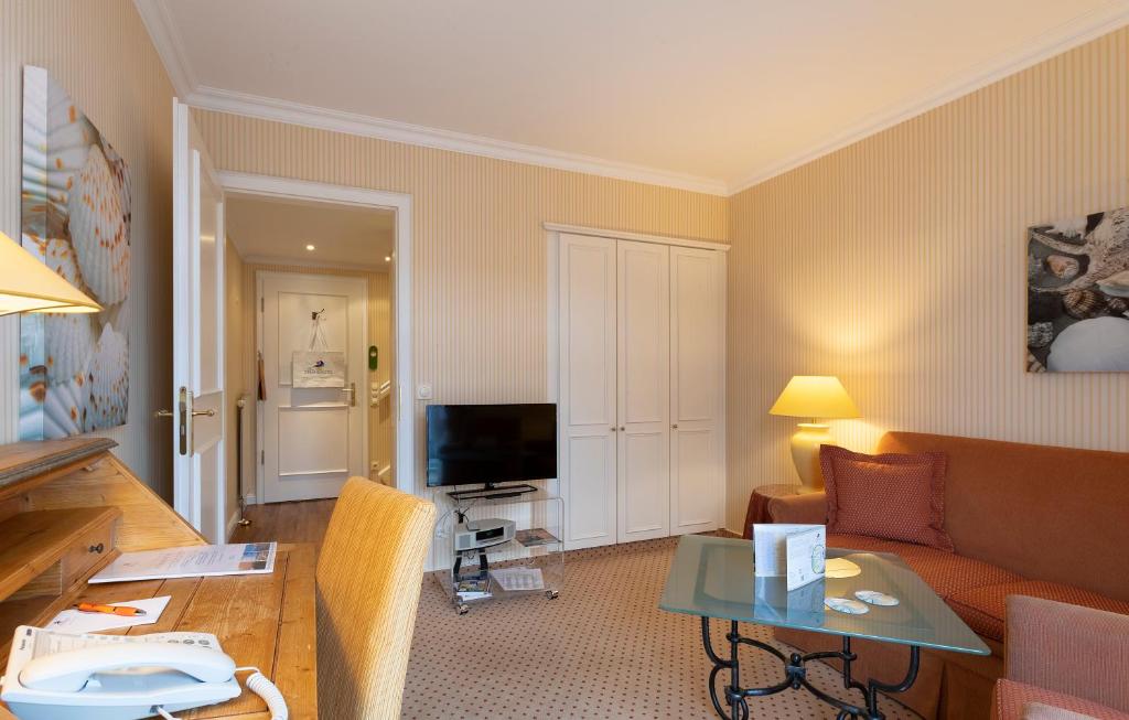 a living room with a couch and a table at Strandhotel Sylt Westerland in Westerland