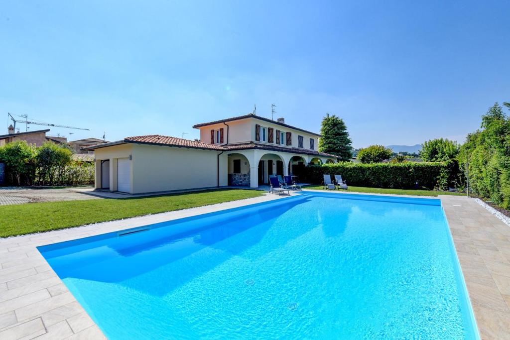 a large swimming pool in front of a house at Villa Sole in Manerba del Garda
