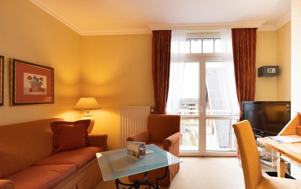 a living room with a couch and a table at Strandhotel Sylt Westerland in Westerland
