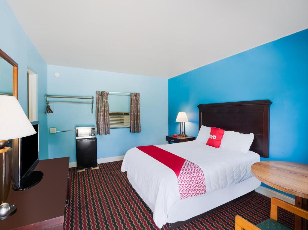 a hotel room with a bed and a table at OYO Hotel Salem-Roanoke I-81 in Salem