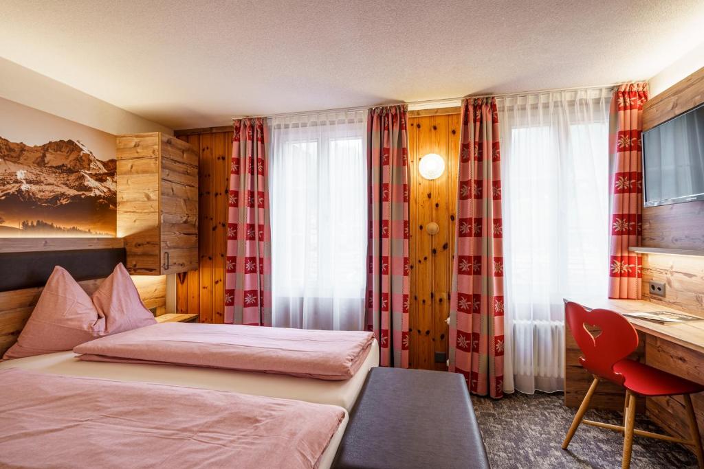 Una cama o camas en una habitación de Alpenblick Hotel & Restaurant Wilderswil by Interlaken