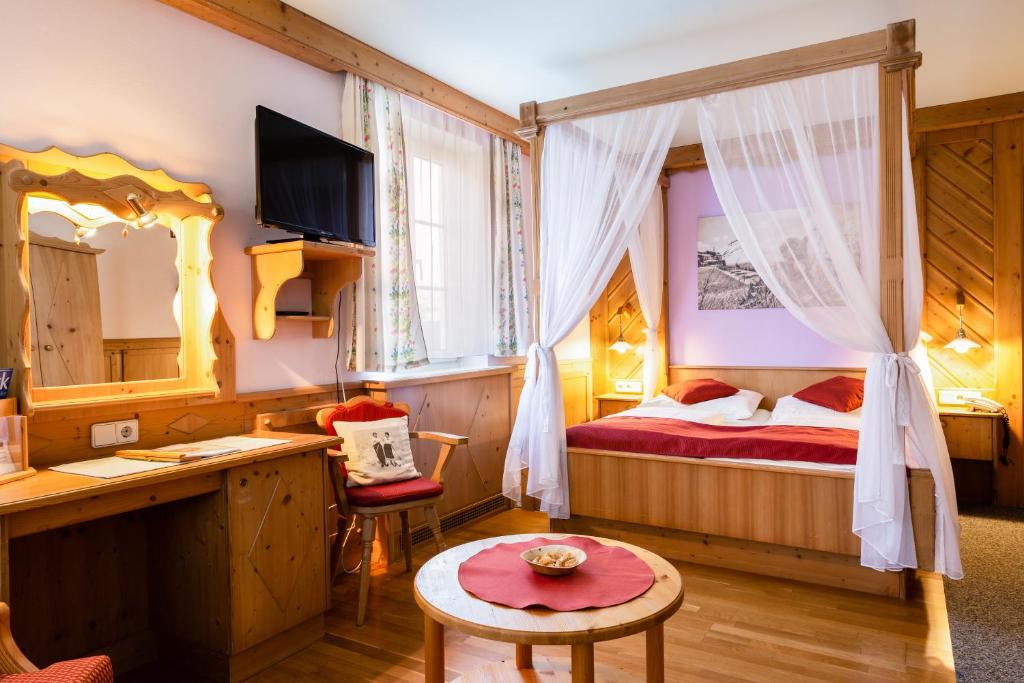 a bedroom with a bed and a desk and a table at Scharfegger's Raxalpenhof - Zuhause am Land in Reichenau