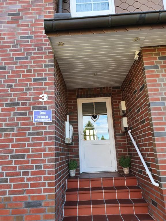 a front door of a brick building with a sign on it at Ferienwohnungen Eisenbarth in Schneverdingen