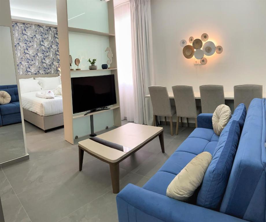 Chic Centre Suites Athens في أثينا: غرفة معيشة بها أريكة زرقاء وتلفزيون