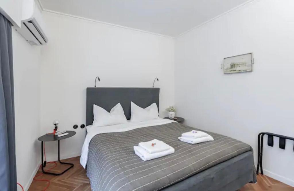 a bedroom with a bed with two towels on it at House in House at the Heart of Exarchia, extremely central in Athens