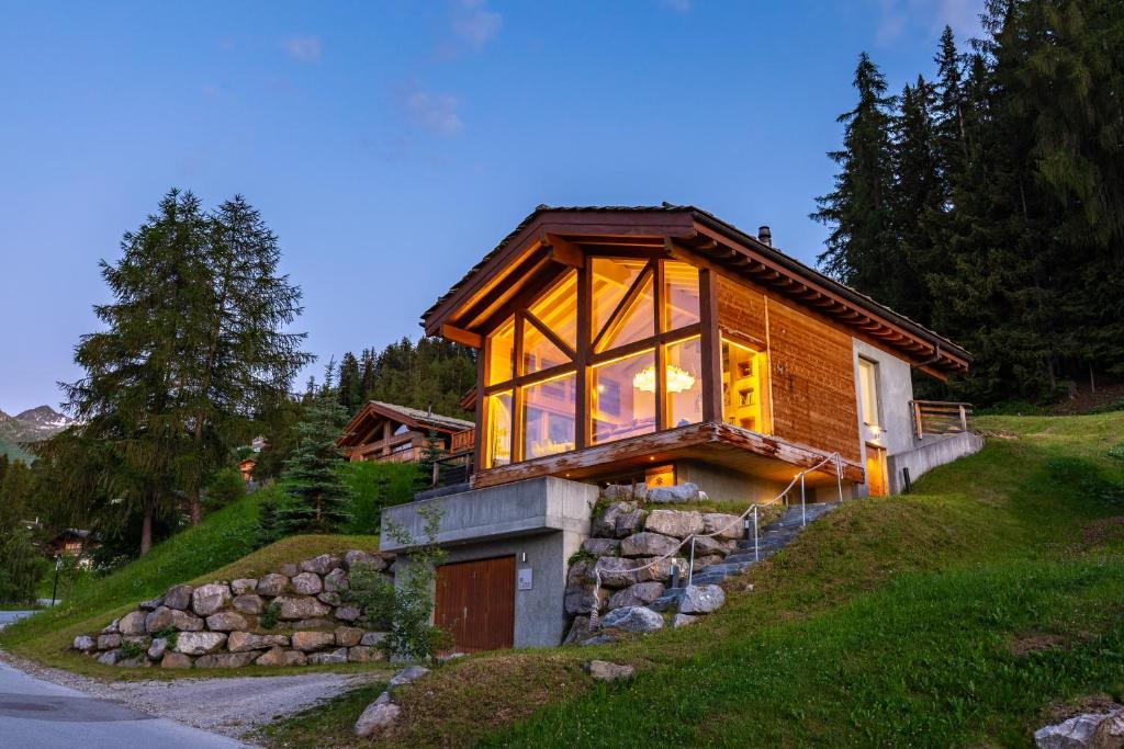 een huis op een heuvel met een groot raam bij Luxury Spa Chalet with Jacuzzi and Sauna in La Tzoumaz