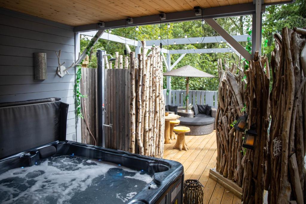 a jacuzzi tub in a backyard with a patio at Chalet à l'aise met Wellness, Durbuy in Durbuy