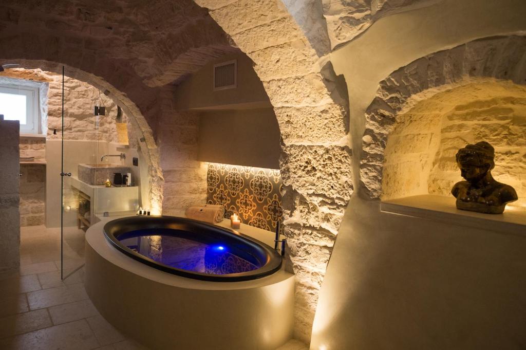 a bathroom with a bath tub in a stone wall at La Mandorla Luxury Trullo in Alberobello