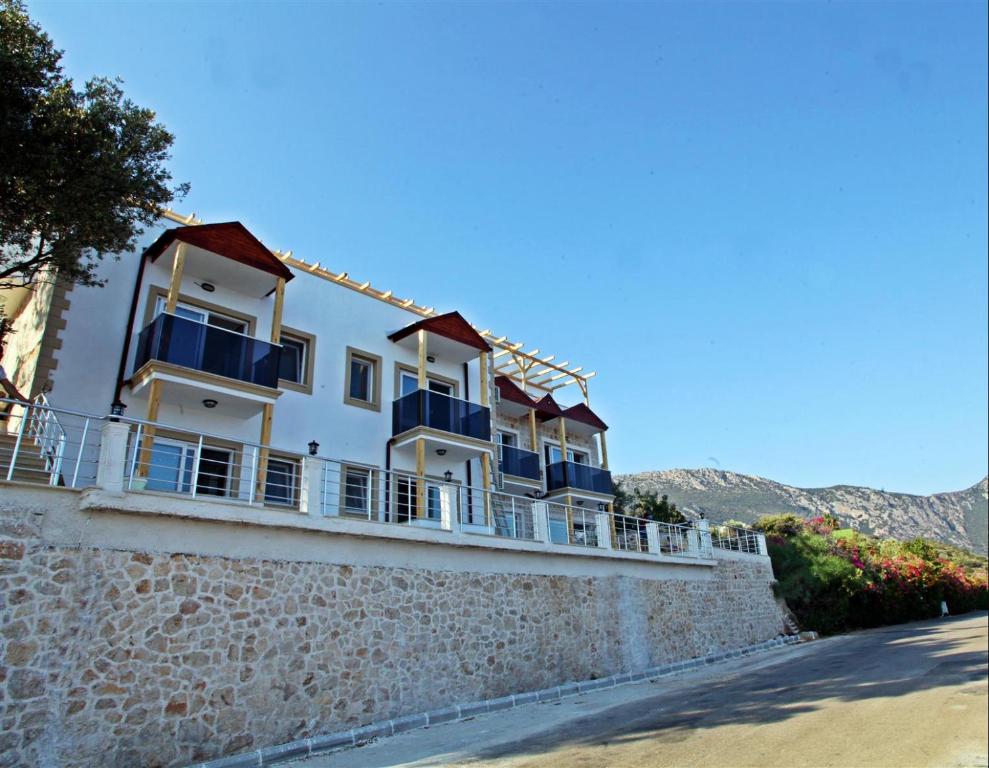 a building with blue balconies on a stone wall at Blue Island Luxury Hotel Adults Only in Kaş