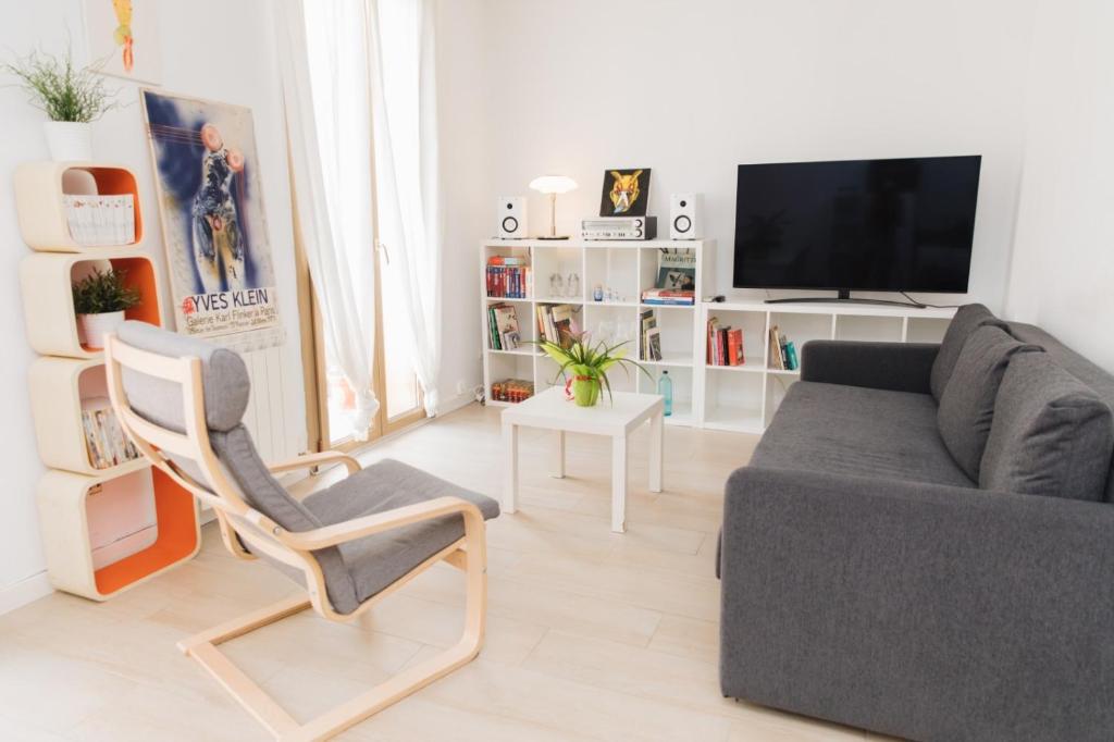 a living room with a couch and a chair and a tv at LA SURFERA APARTMENT in Tarragona