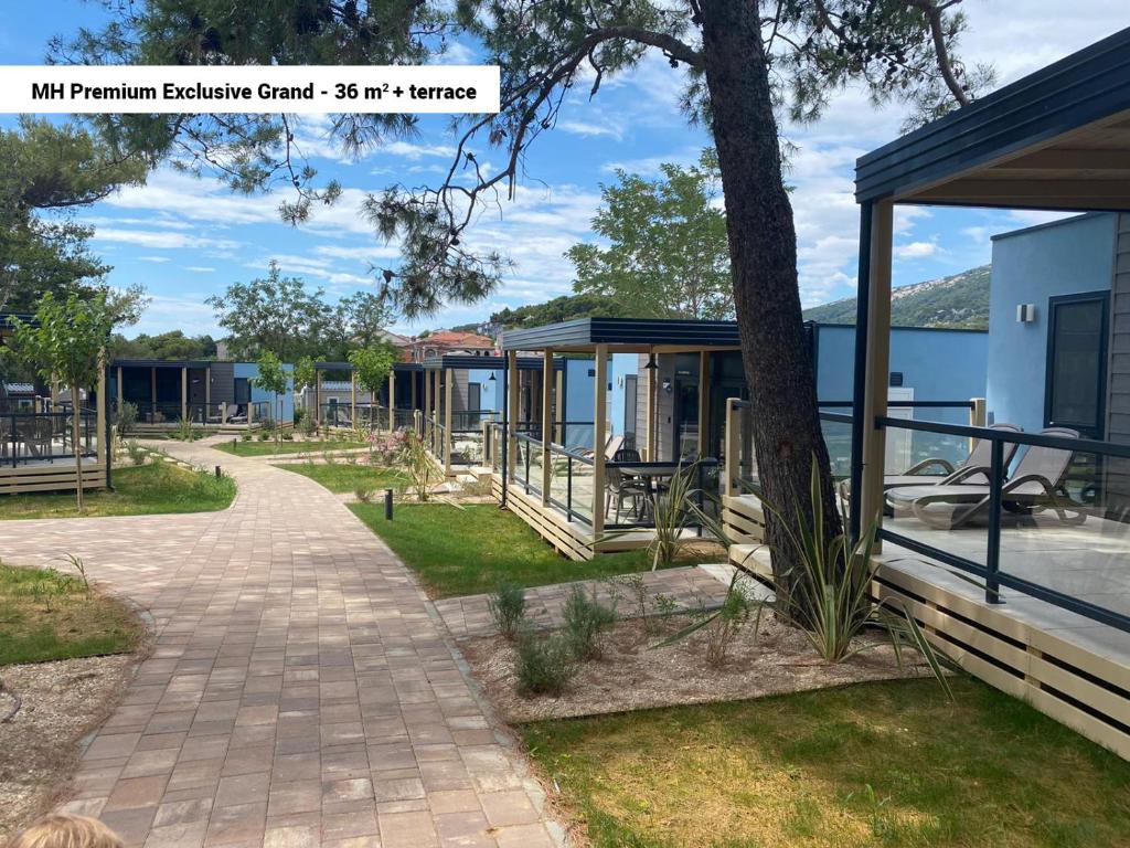 a walkway next to a building with a tree at Victoria Mobilehome in Padova Premium Camping Resort in Banjol