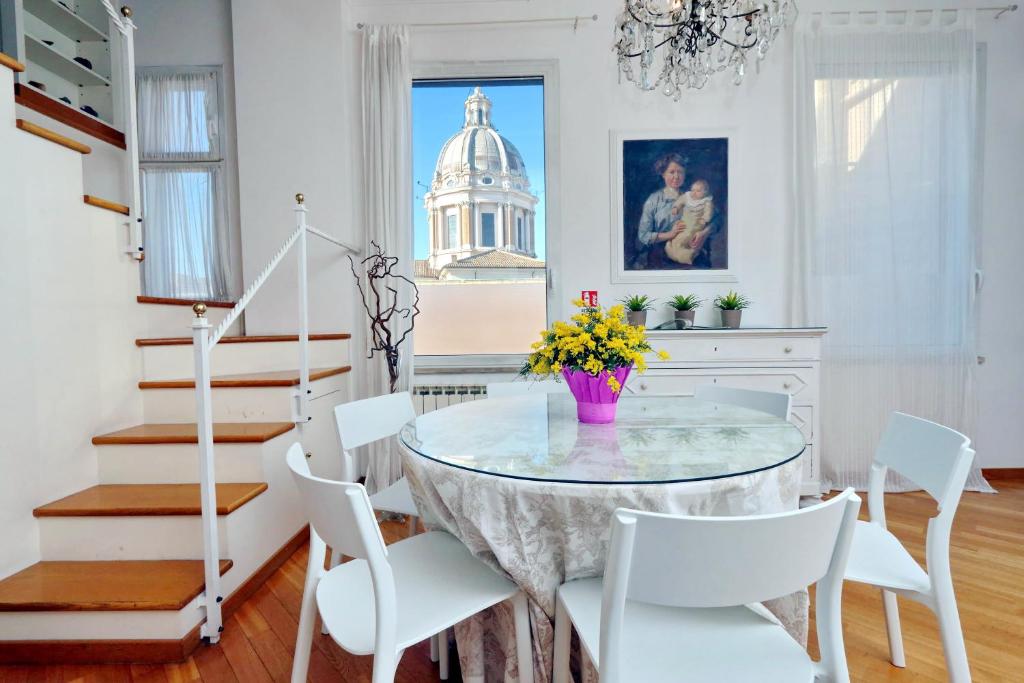a dining room with a glass table and white chairs at RomeAsYouLike - Arancio Apartments N° 10 in Rome