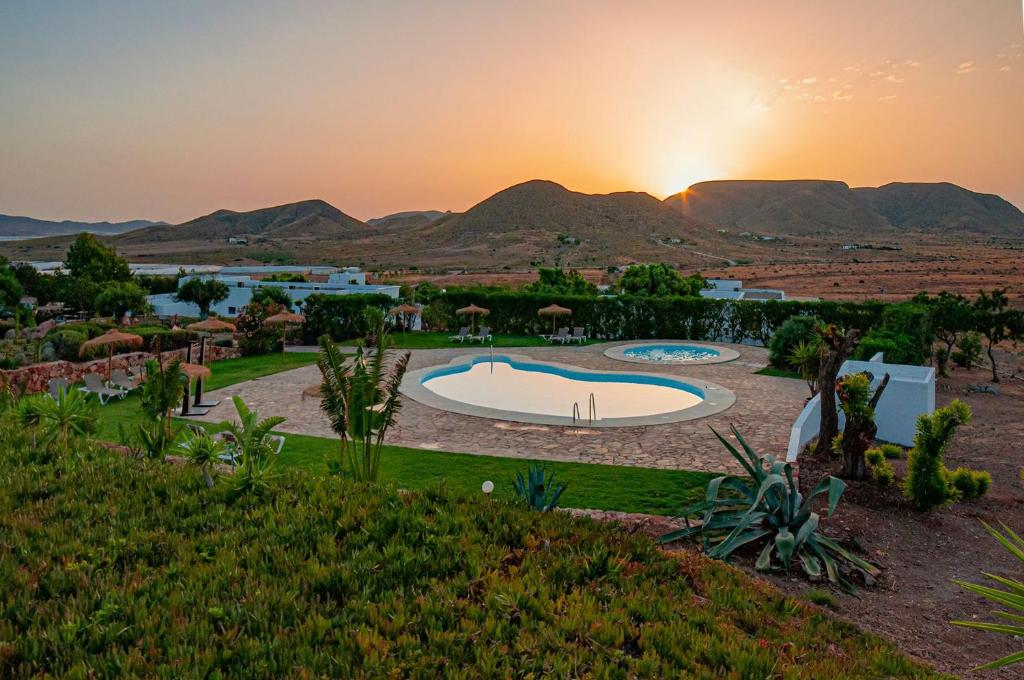 vista su un resort con piscina e tramonto di Finca Maltes San José a El Pozo de los Frailes