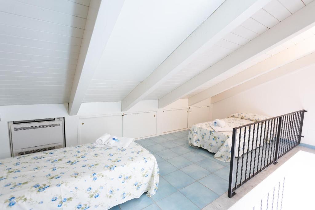 a attic bedroom with two beds and a staircase at LUIMAR Holiday House in Amalfi