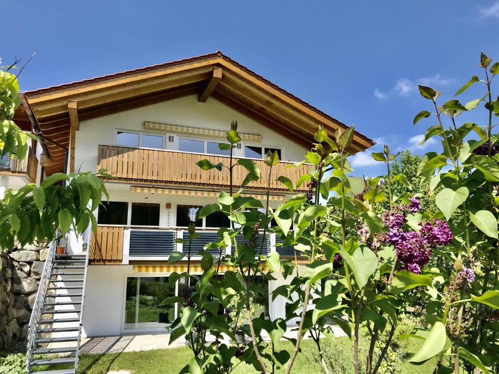 ein Haus mit einem Balkon und einem Baum in der Unterkunft Ferienwohnung Mang in Blaichach