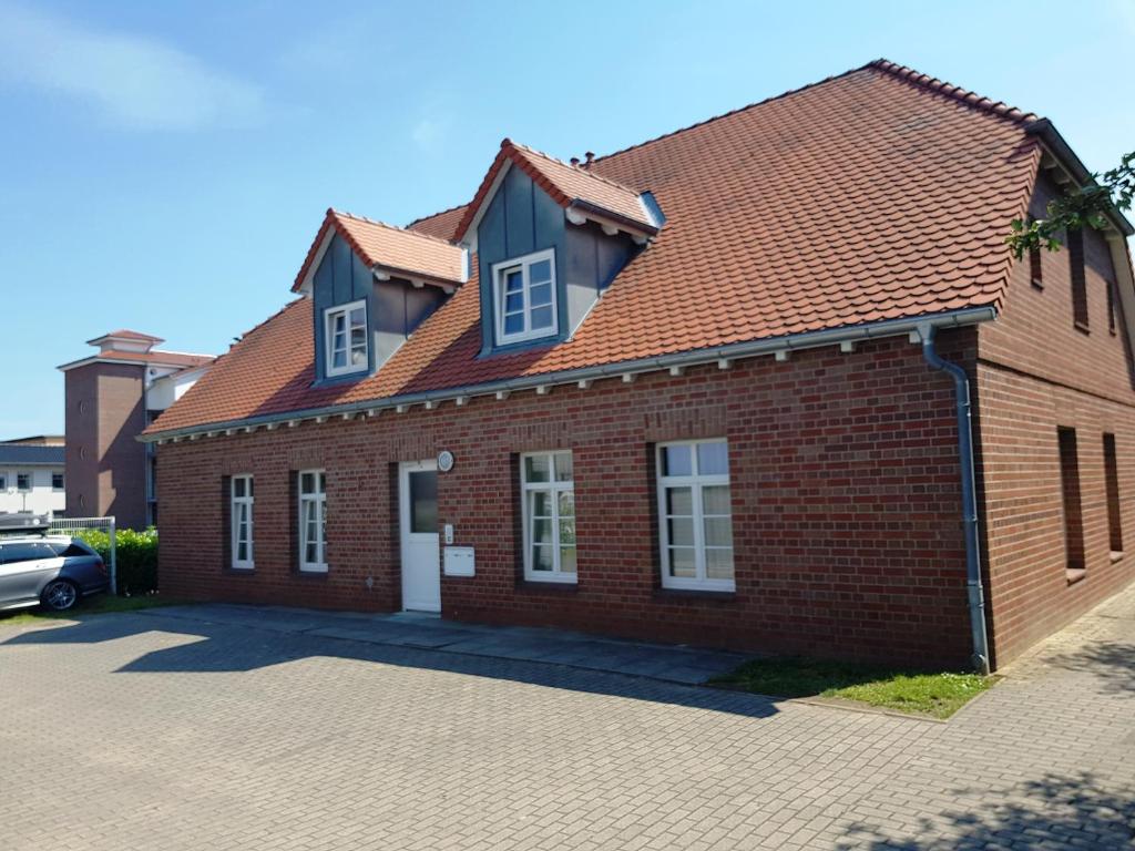 une maison en briques rouges avec un toit rouge dans l'établissement Maisionette Wohnung im Hafenmeisterhaus Lauterbach, à Lauterbach