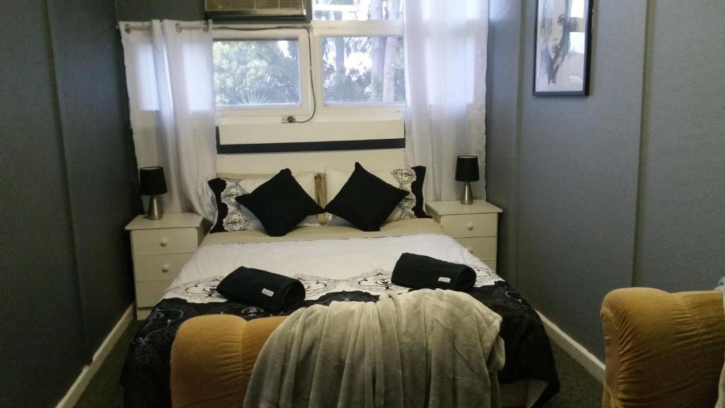 ein Schlafzimmer mit einem Bett mit zwei Taschen darauf in der Unterkunft Wimmera Motel in Nhill