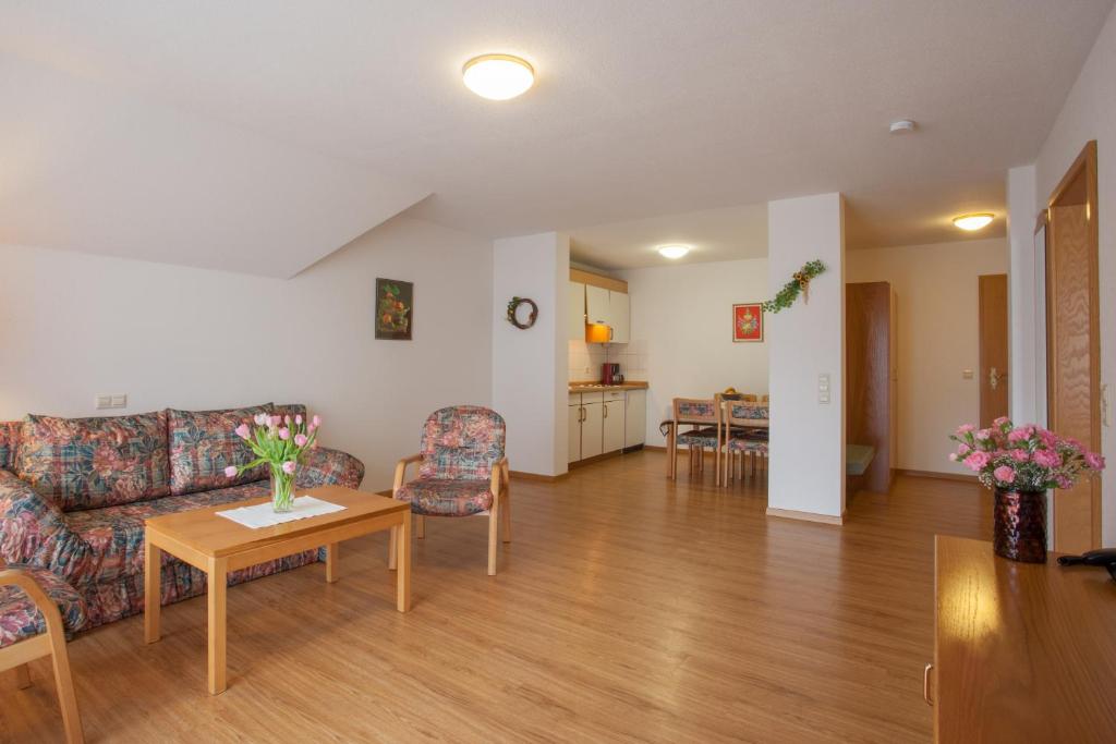 uma sala de estar com um sofá e uma mesa em Rustikale 2 Zi.-FeWo 70 qm Barrierefrei Nähe Freiburg em Simonswald