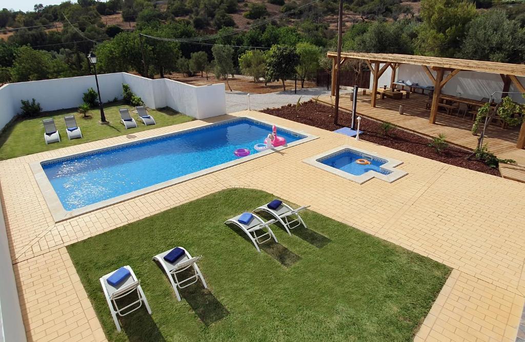 an overhead view of a swimming pool with chairs in a yard at CASA Claudina, Confort et tranquillité in Loulé