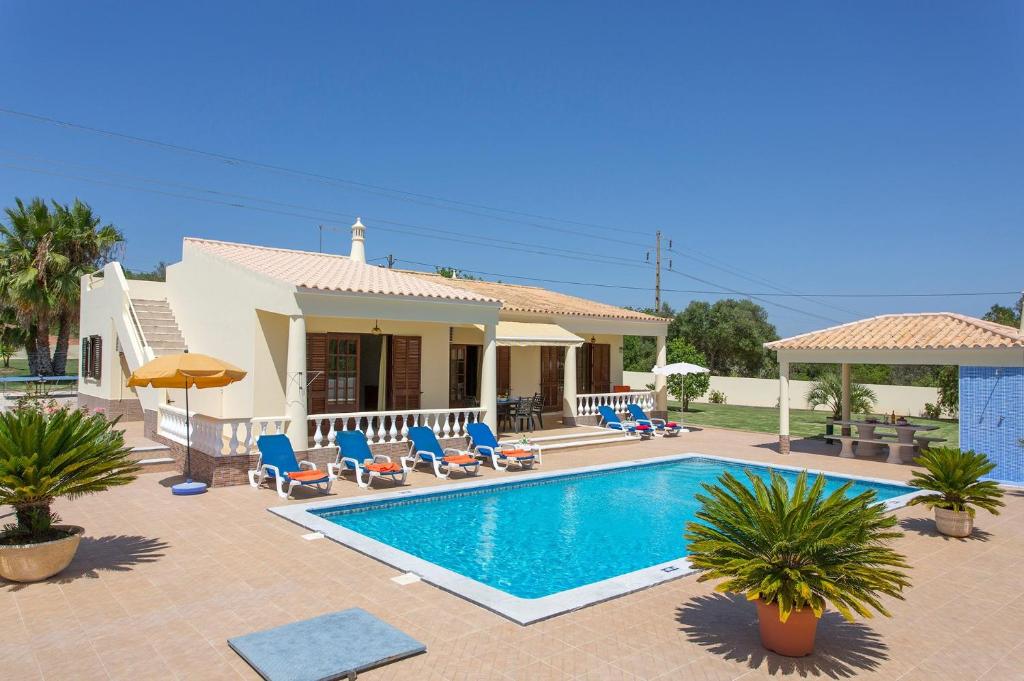 une villa avec une piscine en face d'une maison dans l'établissement Villa Monte Velho, à Albufeira