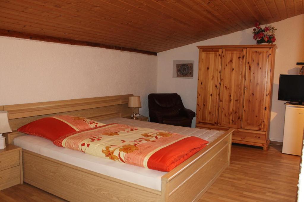 um quarto com uma cama, uma cadeira e uma televisão em Doppelzimmer em Eppingen