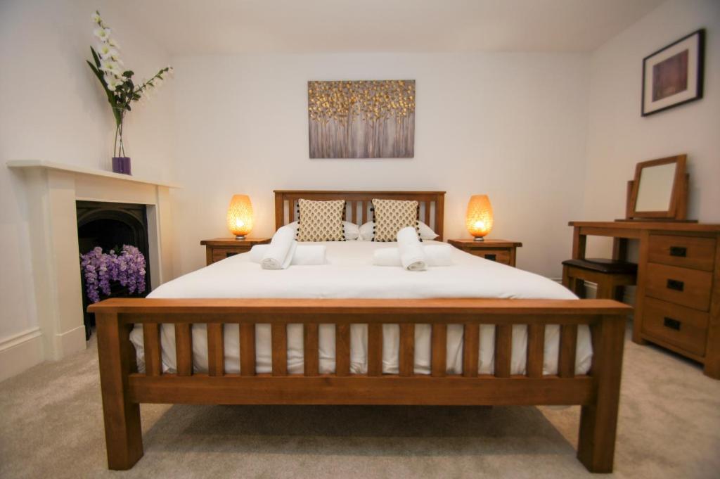 ein Schlafzimmer mit einem großen Bett und einem Kamin in der Unterkunft Montpelier Apartment - Central - by Brighton Holiday Lets in Brighton & Hove